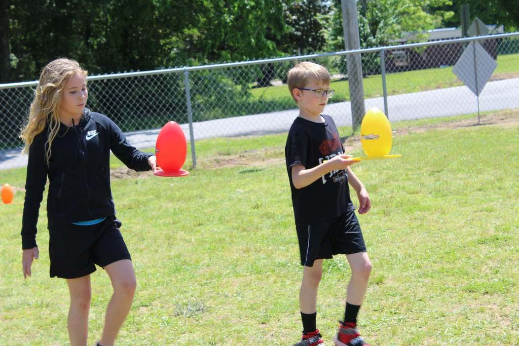 kids holding spoons with eggs