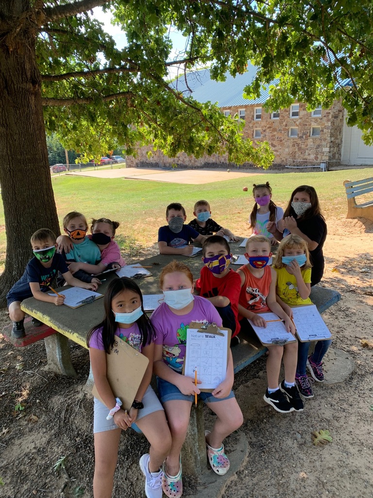 class at picnic table with clipboards