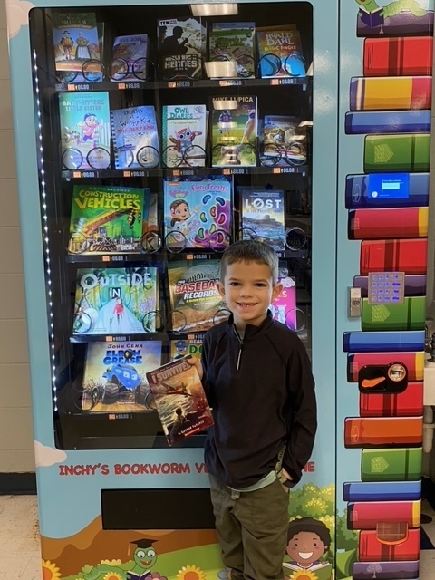 boy with book in front of vending machine